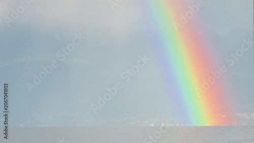 Real Time Rainbow over Lake Geneva and mountain in cloudy day. Preverenges, Vaud, Switzerland.