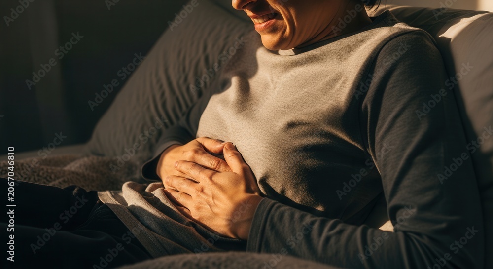 Fototapeta premium Woman Suffering From Stomach Pain Clutching Her Abdomen In Discomfort
