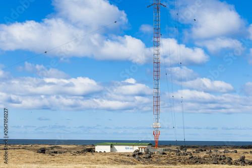 Radio Transmission Tower on Remote Volcanic Coastline in Iceland Under Blue Sky
