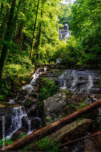 Multi-tiered cascade waterfall flowing through dense green forest at Amicalola Falls State Park, North Georgia mountains, USA.