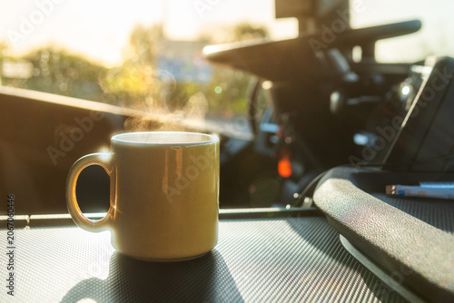 Steaming cup of coffee inside commercial truck cab