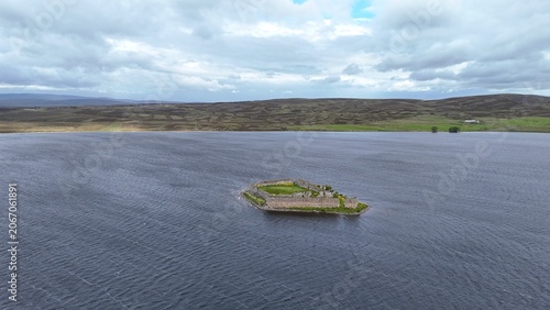 Photos Iochindrob Castle in Scotland overlooks vast sea waters from afar, blending historic grandeur with dramatic coastal scenery and serene natural beauty