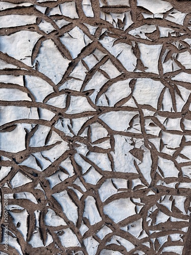 Dry painted surface shows natural cracks after long exposure to heat and loss of moisture. The surface shows irregular shapes created as the paint contracts and separates into uneven sections. 