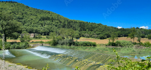 Photography Scenic view of the historic stone weir on the Rufina river in Masseto, Tuscany, Italy
