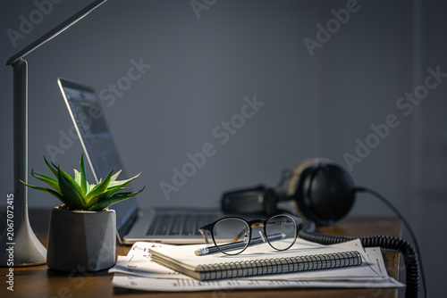 Foto Workplace with headphones and laptop in the evening, copy space.