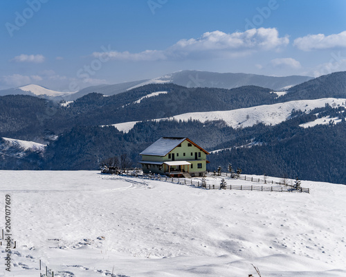Solitary house on a snowy mountain plateau in the Carpathians, Romania