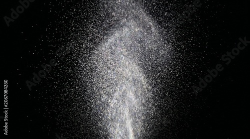 Konstfotografi A fine spray of white mist, water droplets, or powder exploding upwards against a dark background