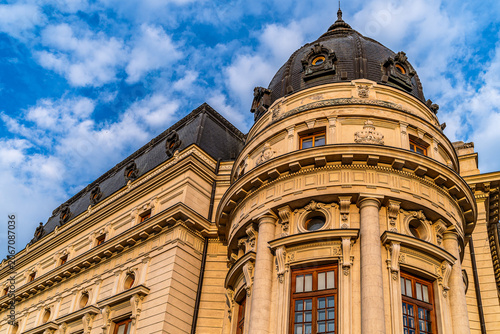 Monumental historic building with dark dome and Corinthian columns in golden light against blue sky, institutional architecture photography.