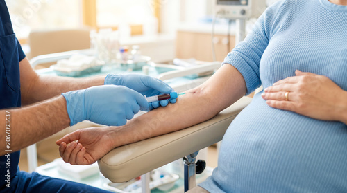 A healthcare worker collects a blood sample from a woman who is pregnant. The woman sits calmly in a clinic while the procedure takes place. The room has medical equipment