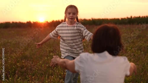 Mother and daughter reunion at sunset, Joyful embrace in the field, Child running into open arms, Family love in nature, Warm evening hugs, Innocent childhood moments, Emotional family connection