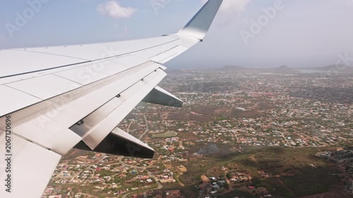 Beautiful view of airplane wing over coastal city and bay seen from window during landing. Dominican Republic.