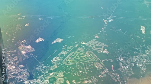 Beautiful view of sprawling cityscape with turquoise lakes and roads seen from airplane window. Miami. USA.