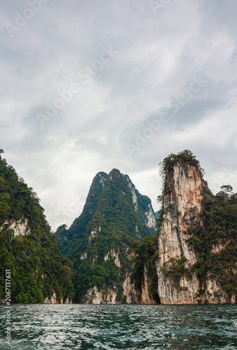 Limestone Cliffs Rising Above Emerald Lake in Tropical Rainforest