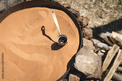 Canvas Print Metal cezve with coffee brewing in hot sand using a traditional Turkish coffee preparation method
