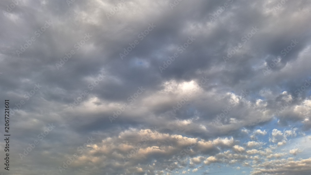 Obraz premium Overcast sky with grey storm clouds and sunset light