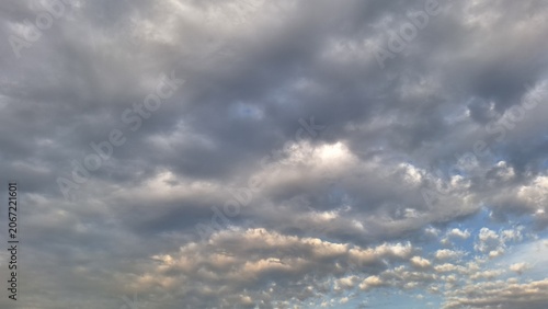 Overcast sky with grey storm clouds and sunset light