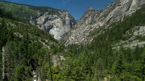 Aerial view of Yosemite Valley showcasing dramatic granite cliffs, lush forests, and winding river under natural daylight in California’s Sierra Nevada.