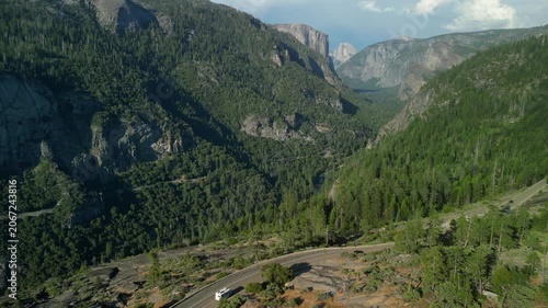 Aerial view of Yosemite Valley showcasing dramatic granite cliffs, lush forests, and winding river under natural daylight in California’s Sierra Nevada.