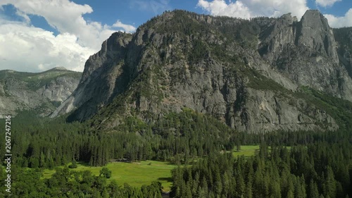 Aerial view of Yosemite Valley showcasing dramatic granite cliffs, lush forests, and winding river under natural daylight in California’s Sierra Nevada.