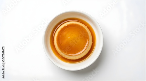 Top view of smooth caramel custard flan in small bowl, creamy egg pudding dessert, sweet treat, tasty homemade snack, gourmet food