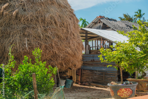 Large traditional haystack next to rustic outbuildings in a rural yard