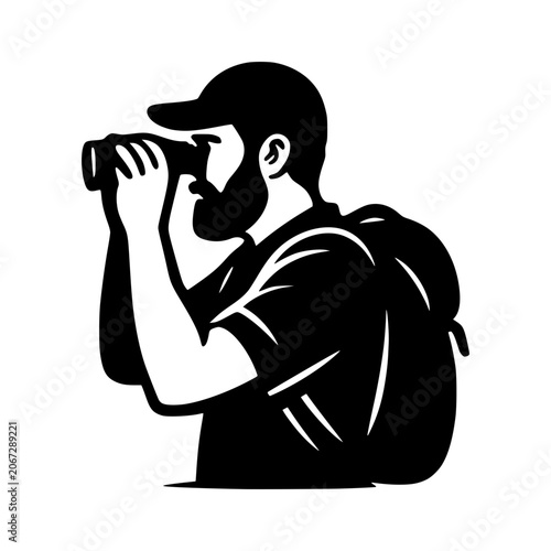 Backpacker Photographer Capturing the Moment: A man wearing a cap and backpack, engrossed in using his camera, signifies exploration and the art of photography.