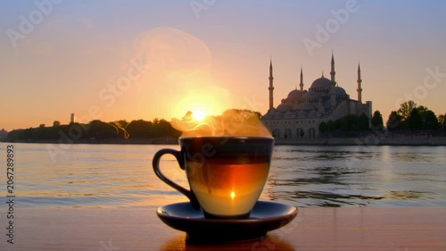 Steaming cup of tea at sunrise overlooking a historic mosque and river. Seamless looping 4k video background