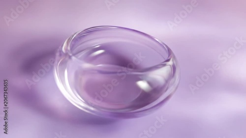 Transparent glass bowl on soft purple background with diffused light