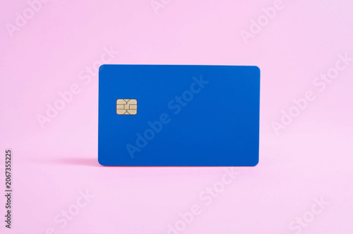 Blank blue credit or debit card with EMV chip isolated on a pastel pink background.