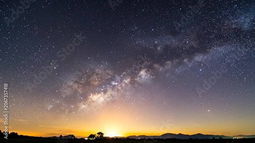 A vibrant night sky filled with stars above a dark horizon