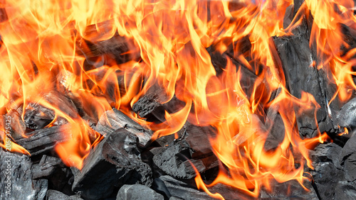 Burning charcoal with bright orange flames.