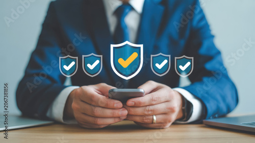 Businessman using smartphone with security shield icons for protection