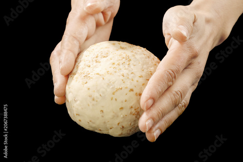 Hands Holding Fresh Whole Wheat Bread Dough Ball on Black Background - Artisanal Baking Concept