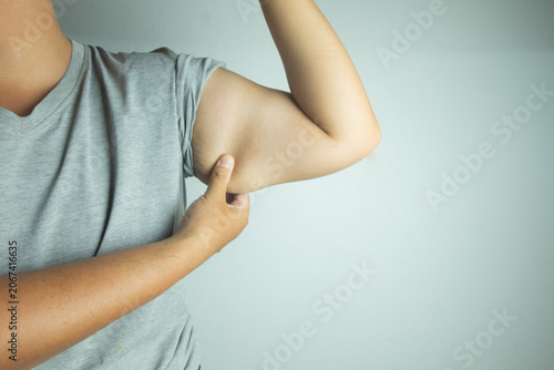 Vászonkép Close up of overweight man pinching flabby fat on his upper arm