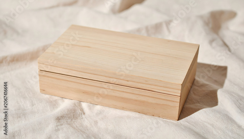 Simple closed wooden keepsake box on soft beige linen cloth background