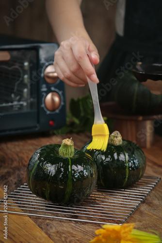 Foto Brushing Oil on Fresh Small Round Zucchini in Kitchen