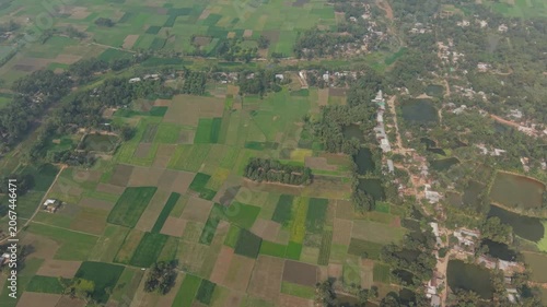 Aerial Landscape View with Patchwork Fields, Wooded Areas, and a Winding River Reflecting Calm Rural Countryside