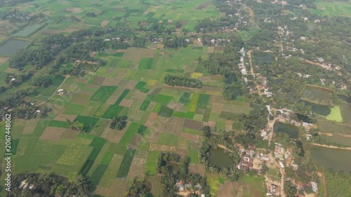 Aerial Landscape of Rural Farmland Patches with a Winding Road, River, and Scattered Houses Under Soft Daylight