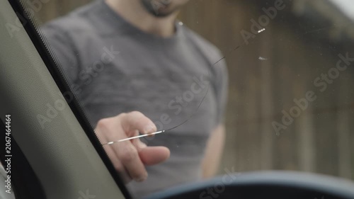 Male person check the fractured windscreen on the car view from inside 4K
