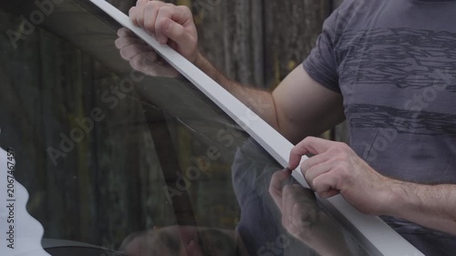 Male person in reflection check the fractured windscreen on the car 4K
