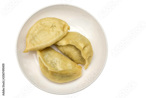Momos or gyoza on a white plate with copy space.