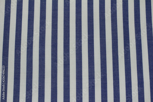 Texture of blue striped cotton cloth background. Close up of classic blue and white vertical striped fabric.	