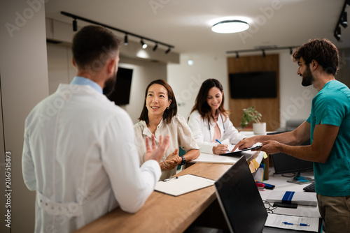 Schilderij op canvas Healthcare professionals assisting patient at clinic reception desk