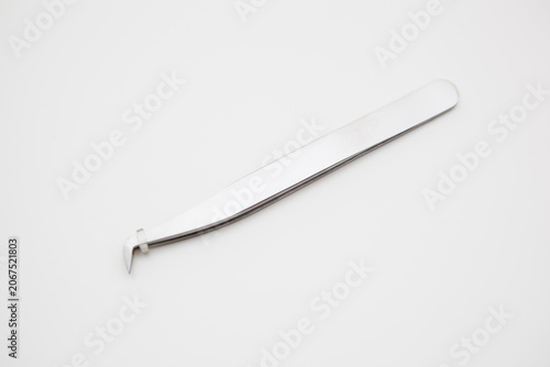tools for eyelash extension and eyebrow design. cosmetic tweezers in silver color on a white background