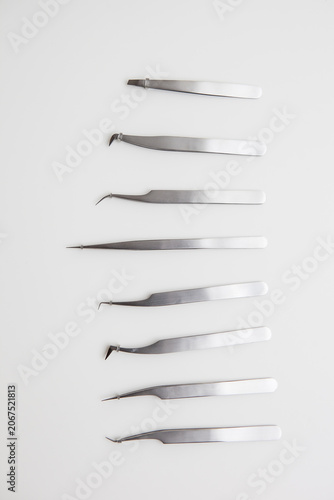 tools for eyelash extension and eyebrow design. cosmetic tweezers in silver color on a white background