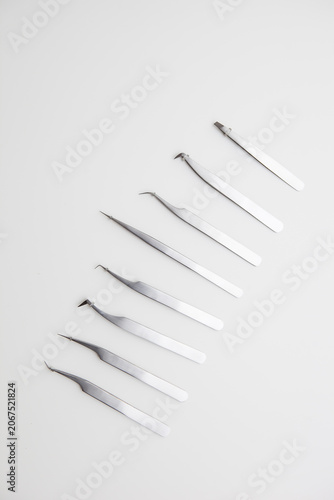 tools for eyelash extension and eyebrow design. cosmetic tweezers in silver color on a white background