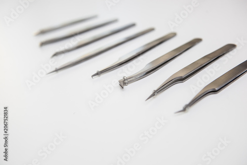 tools for eyelash extension and eyebrow design. cosmetic tweezers in silver color on a white background