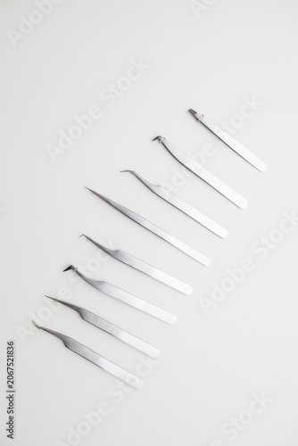 tools for eyelash extension and eyebrow design. cosmetic tweezers in silver color on a white background