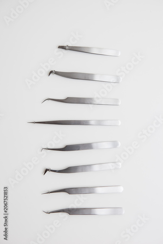 tools for eyelash extension and eyebrow design. cosmetic tweezers in silver color on a white background