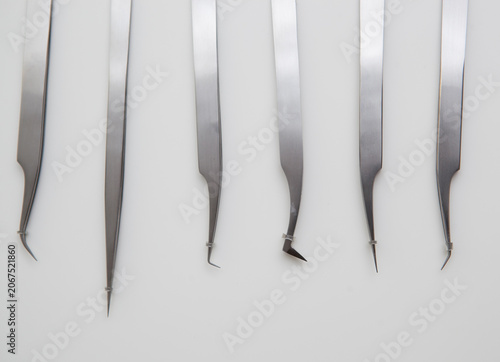 tools for eyelash extension and eyebrow design. cosmetic tweezers in silver color on a white background